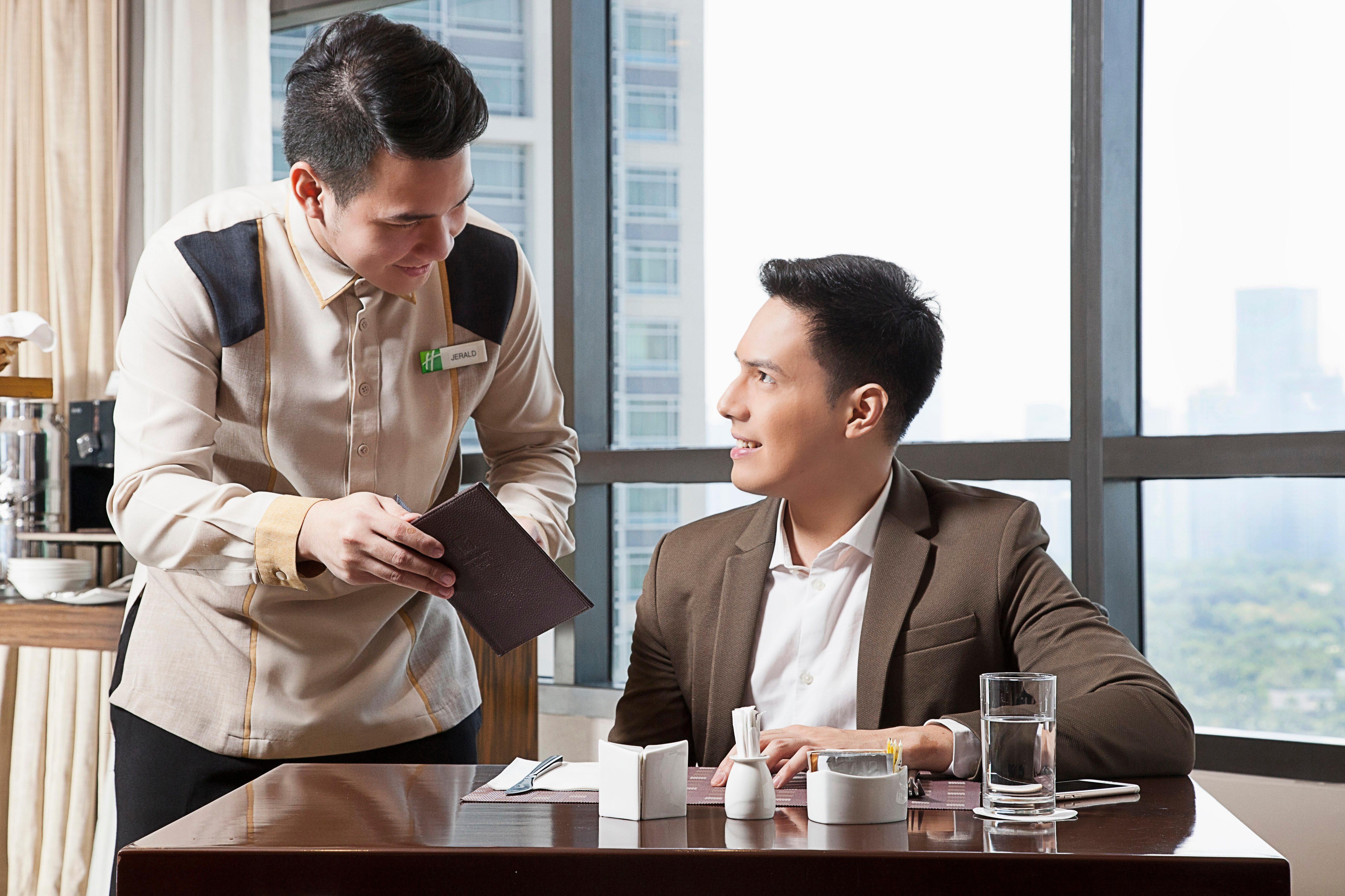 Holiday Inn & Suites Makati By Ihg San Pedro Makati Exterior foto A butler serving a guest